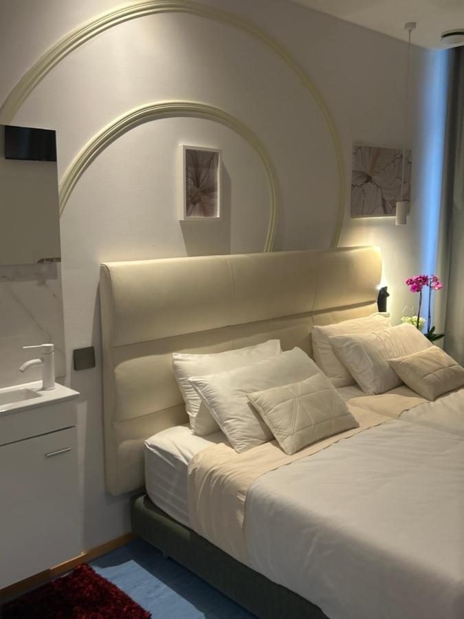 Quarto com cabeceira em tecido e candeeiros de leitura
