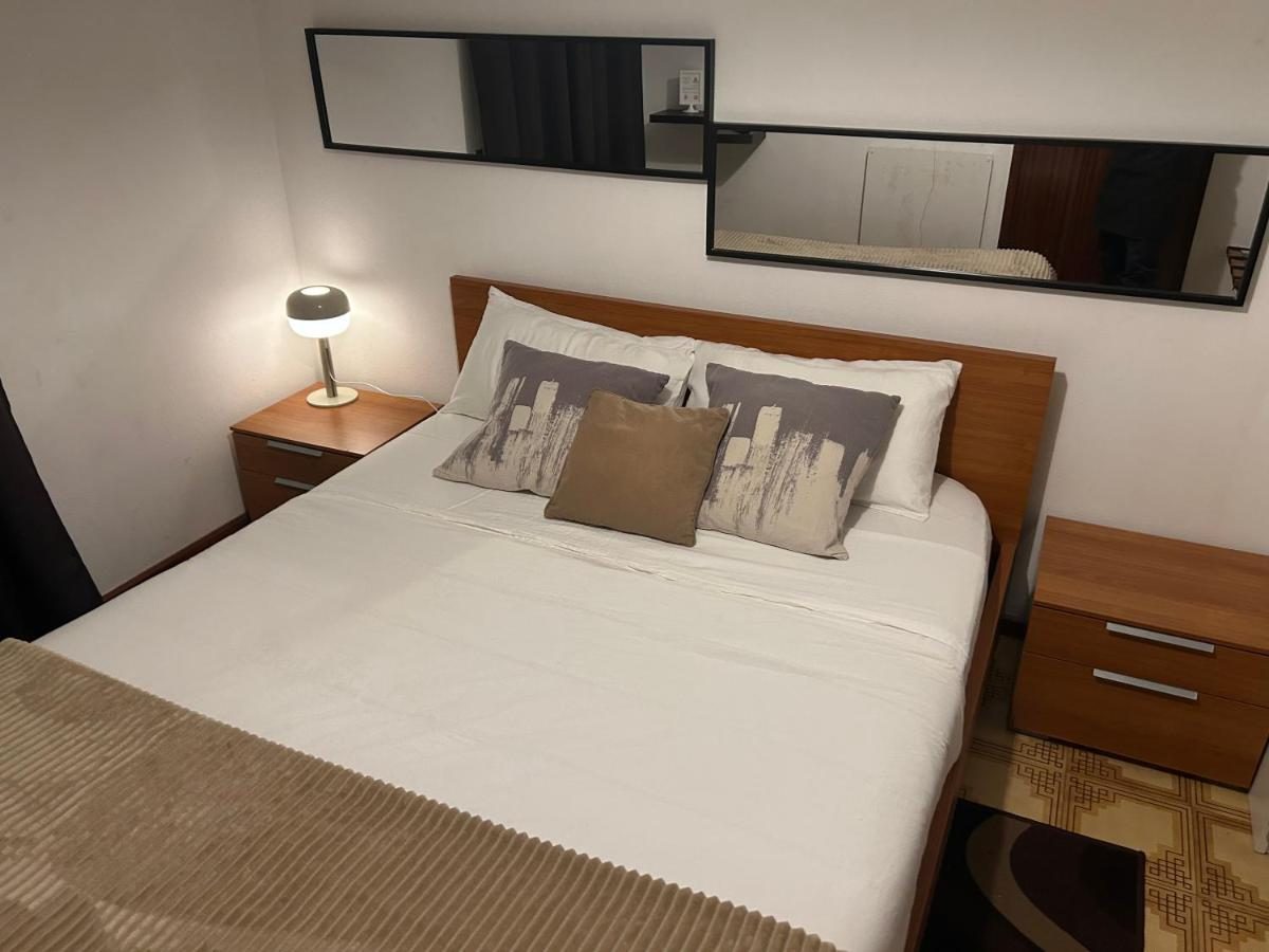 Quarto com cama de casal e mesas de cabeceira em madeira
